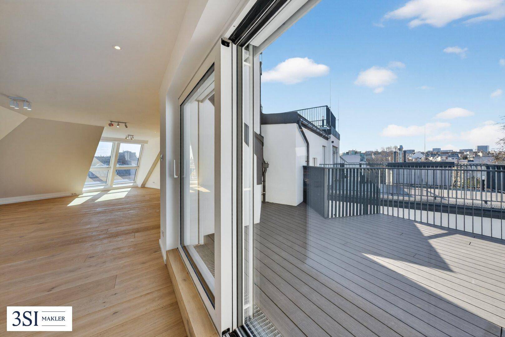Heller Wohnbereich mit Holzboden und großem Schiebefenster, das Zugang zur Dachterrasse bietet.