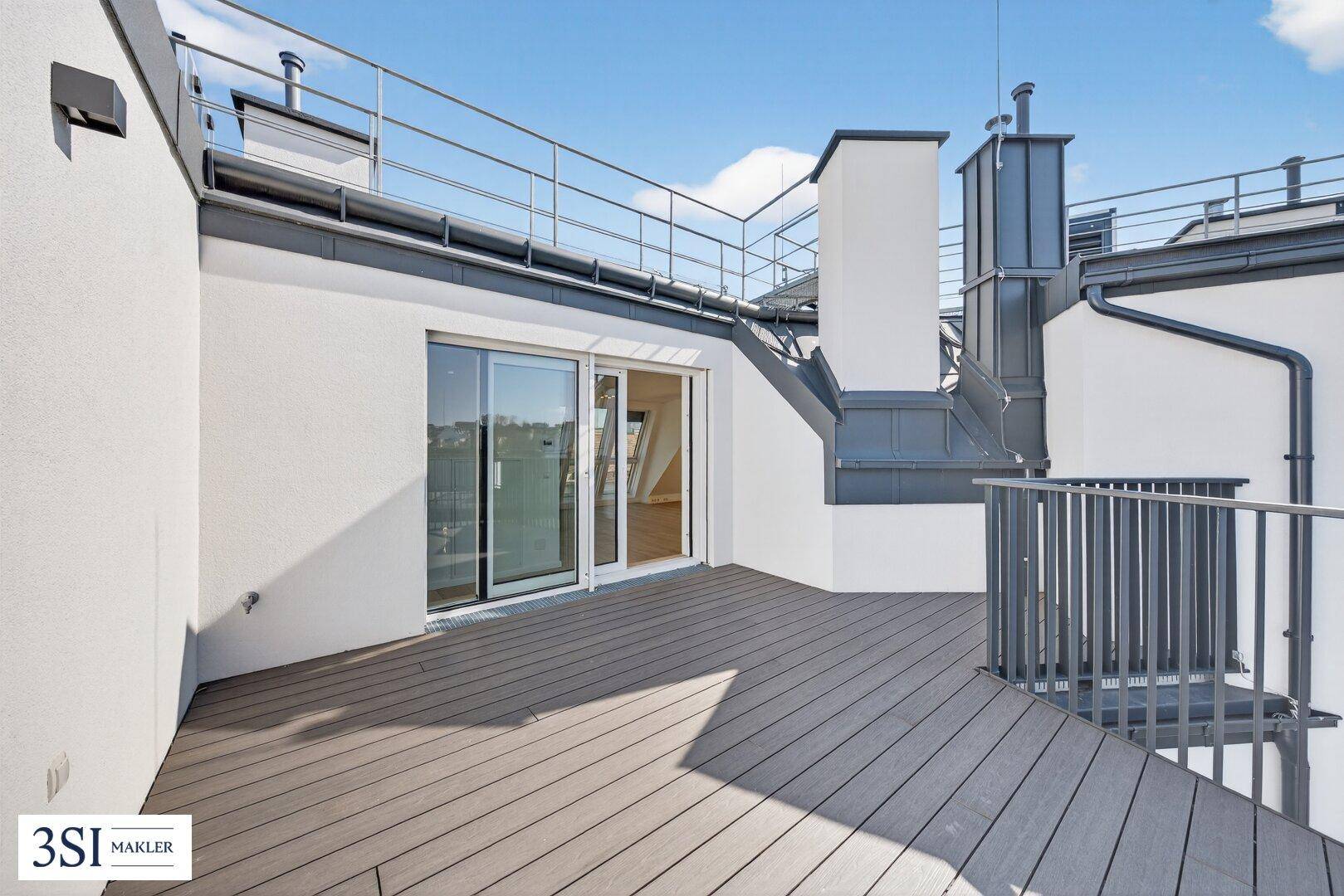 Geräumige Dachterrasse mit Holzdielen und Zugang zum Innenbereich, umgeben von modernen Geländern.