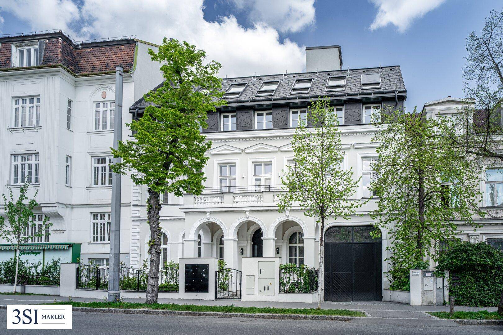 Elegante Straßenfassade des Gebäudes mit klassischer Architektur und gepflegtem Eingangsbereich.