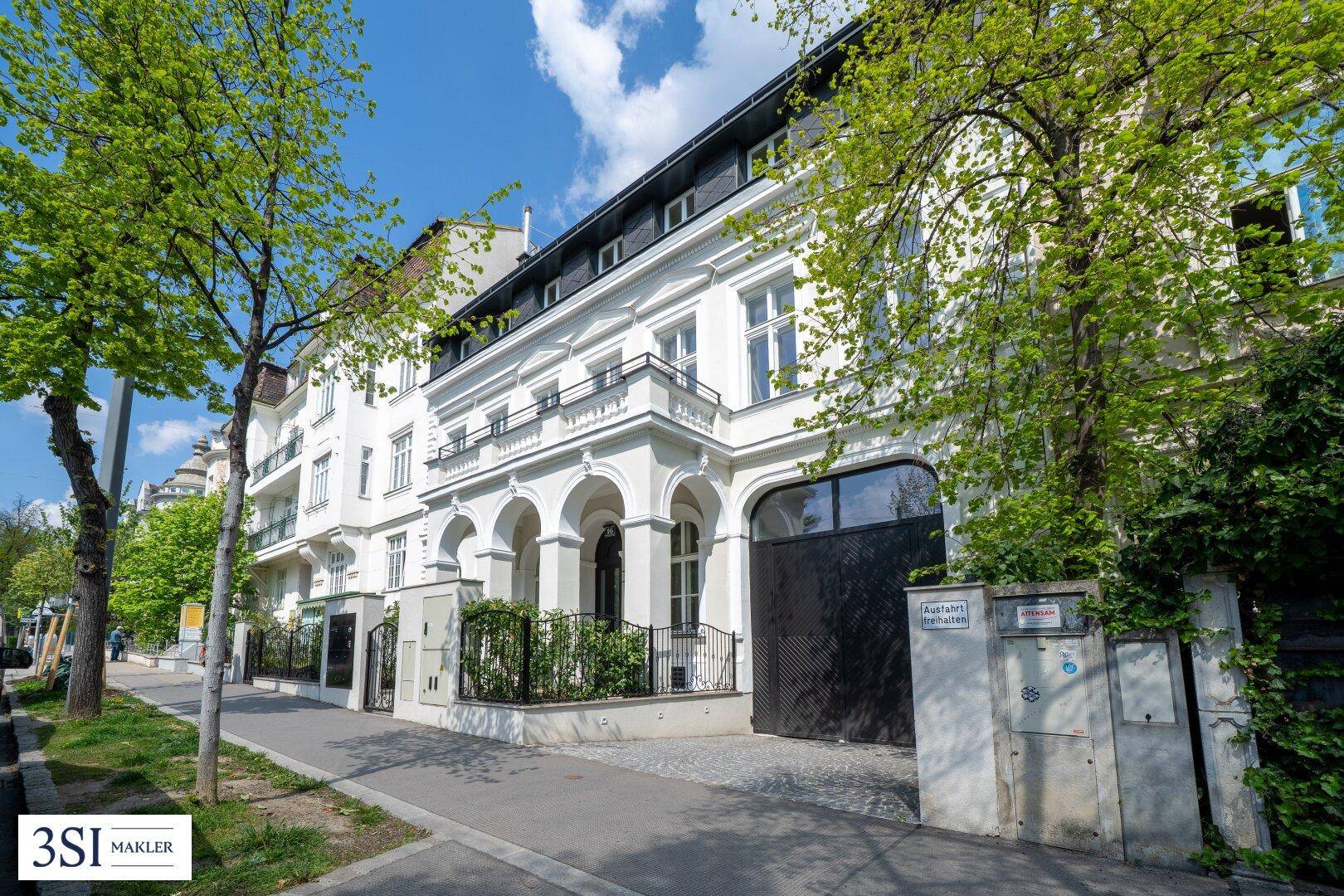 Repräsentative Fassade des Stadthauses mit klassizistischen Elementen und gepflegter Umgebung.