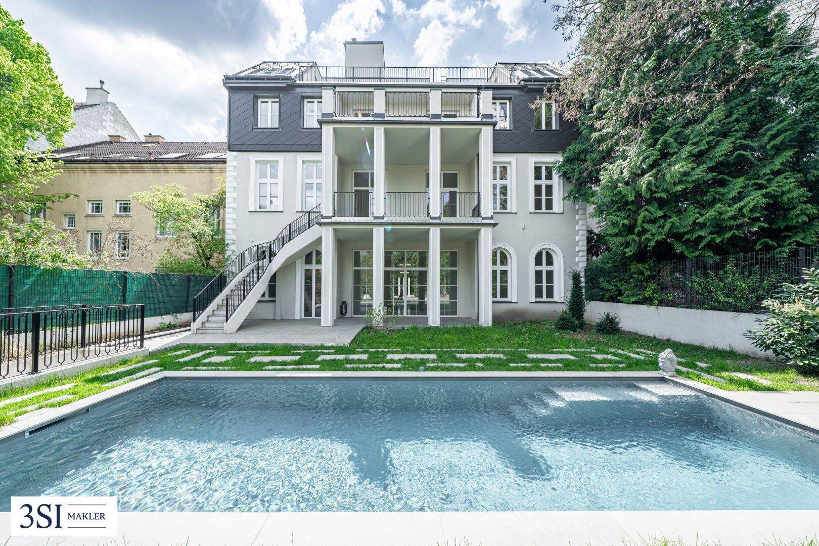 Weitläufiger Garten mit großem Swimmingpool und Blick auf die beeindruckende Gebäudefassade.