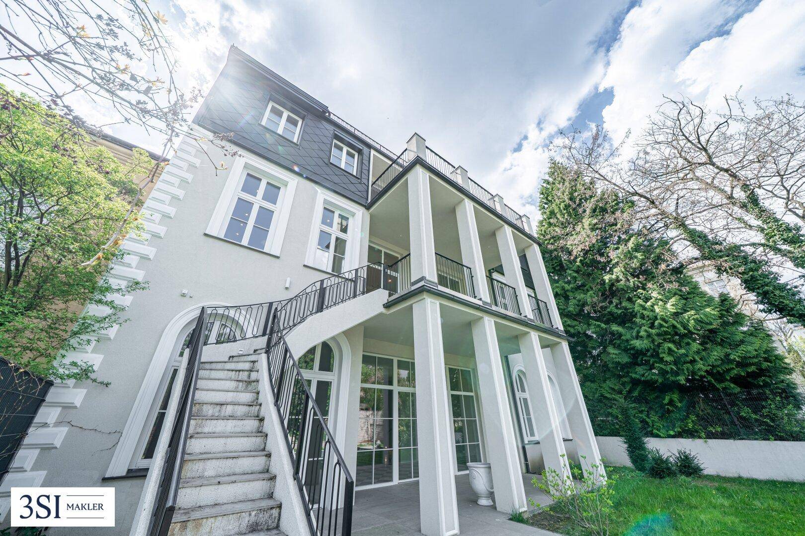 Beeindruckende Rückfassade des Gebäudes mit mehreren Balkonen und Zugang zum Garten.