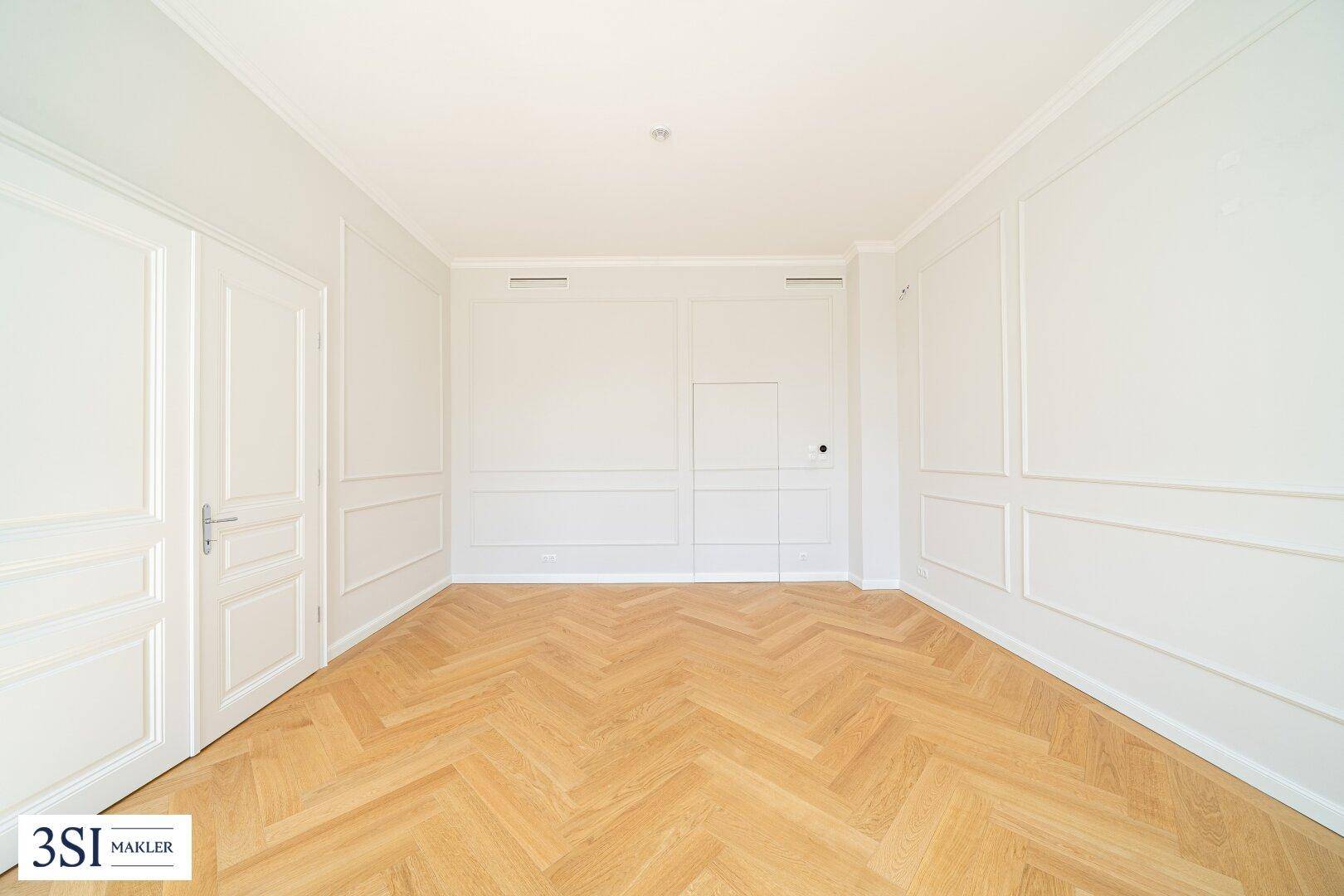 Ruhiges Schlafzimmer mit Fischgrätparkett und schlichten, eleganten Wandpaneelen.