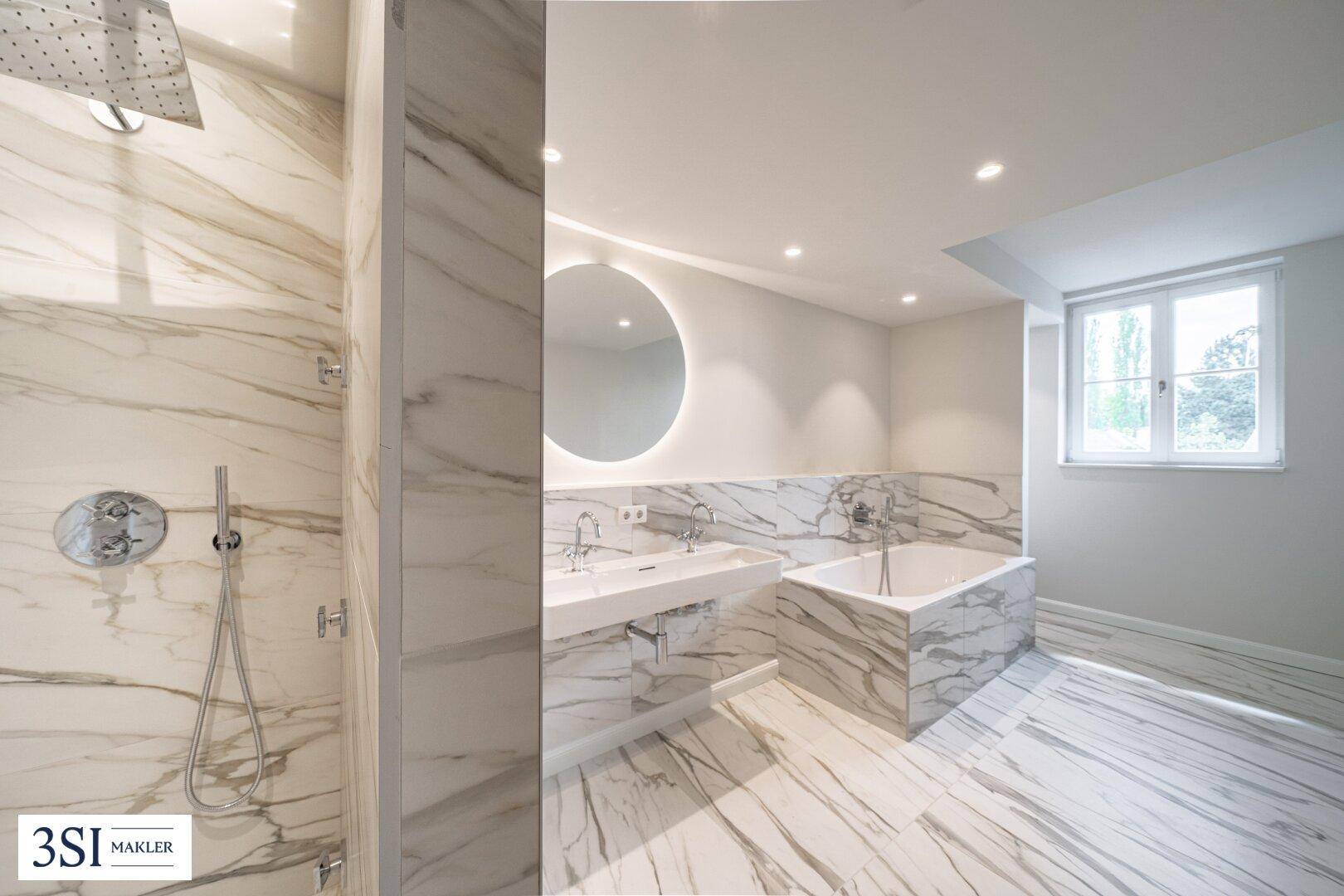 Luxuriöses Badezimmer mit Marmorfliesen, Doppelwaschbecken und großer begehbarer Dusche.
