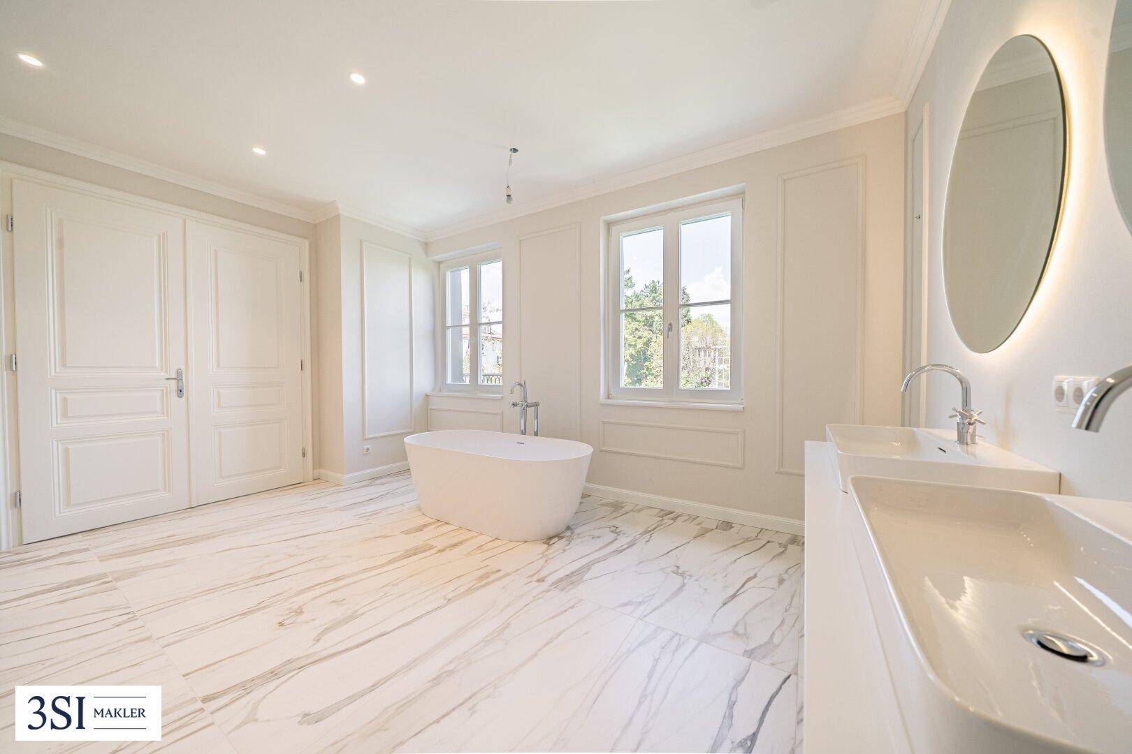 Geräumiges Badezimmer mit freistehender Badewanne, Doppelwaschbecken und Marmorboden.