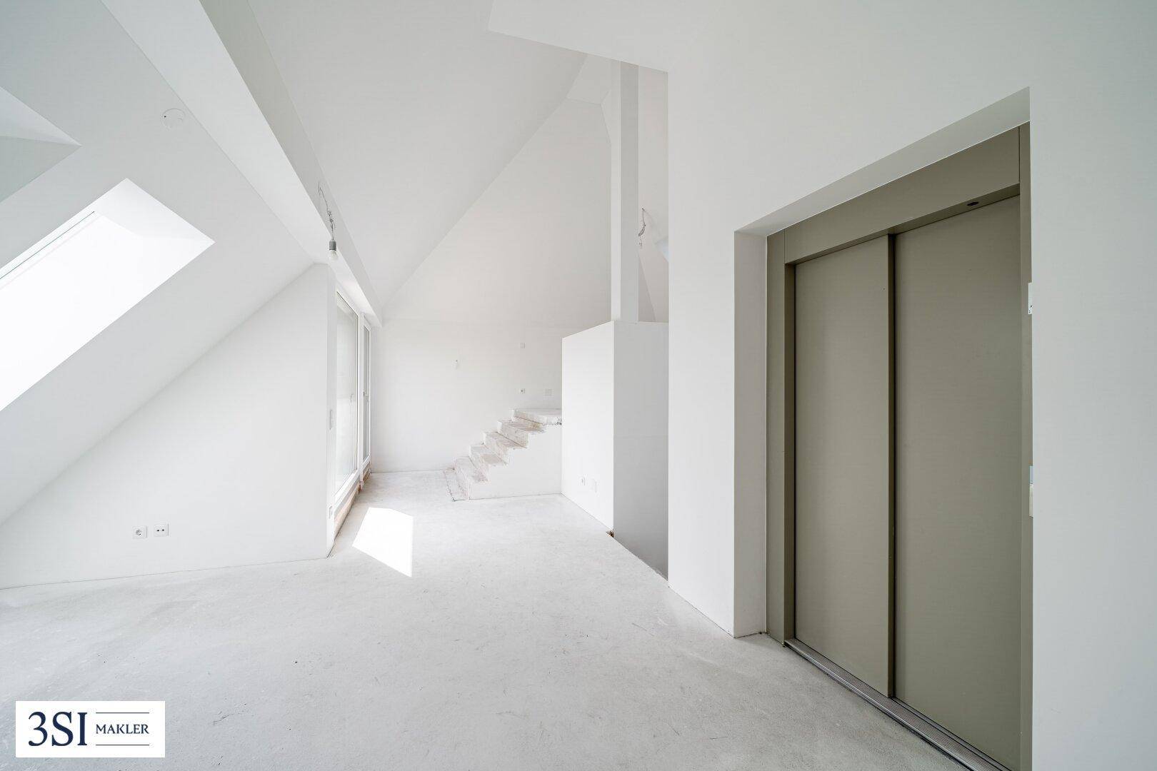 Geräumiger Dachboden im Rohbauzustand mit Aufzug und Dachfenstern, ideal für Loft-Ausbau.