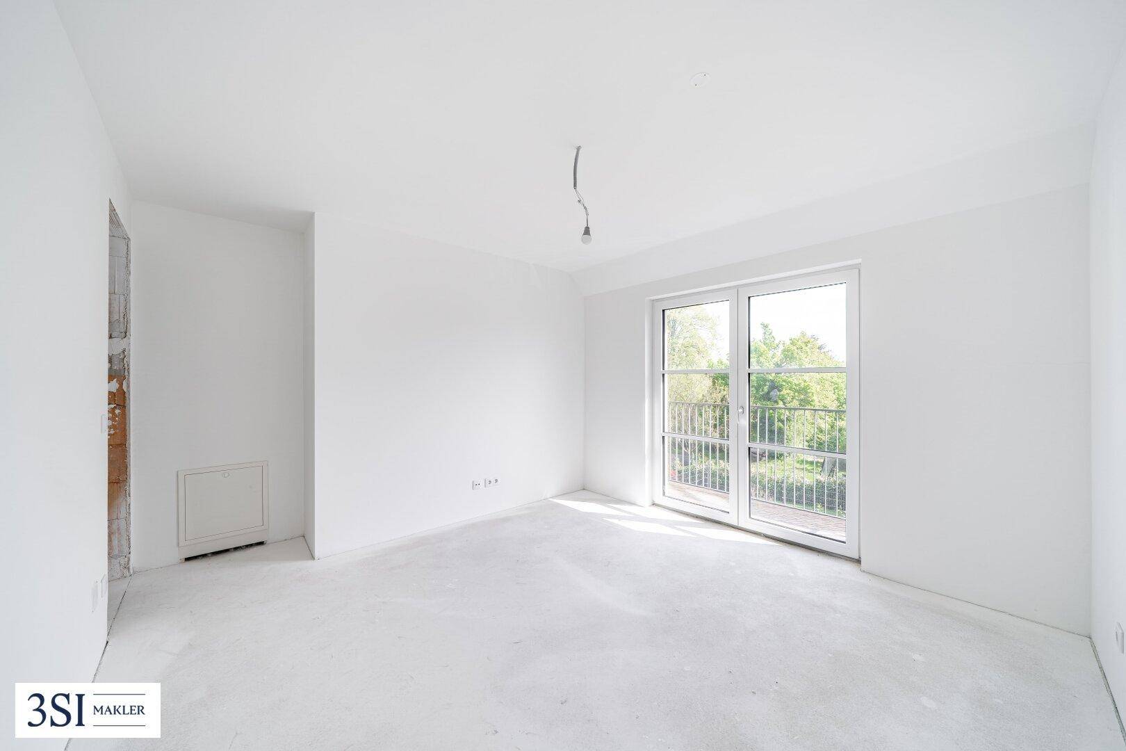 Heller, unfertiger Raum mit großer Fenstertür und Blick ins Grüne, ideal für ein Schlafzimmer.