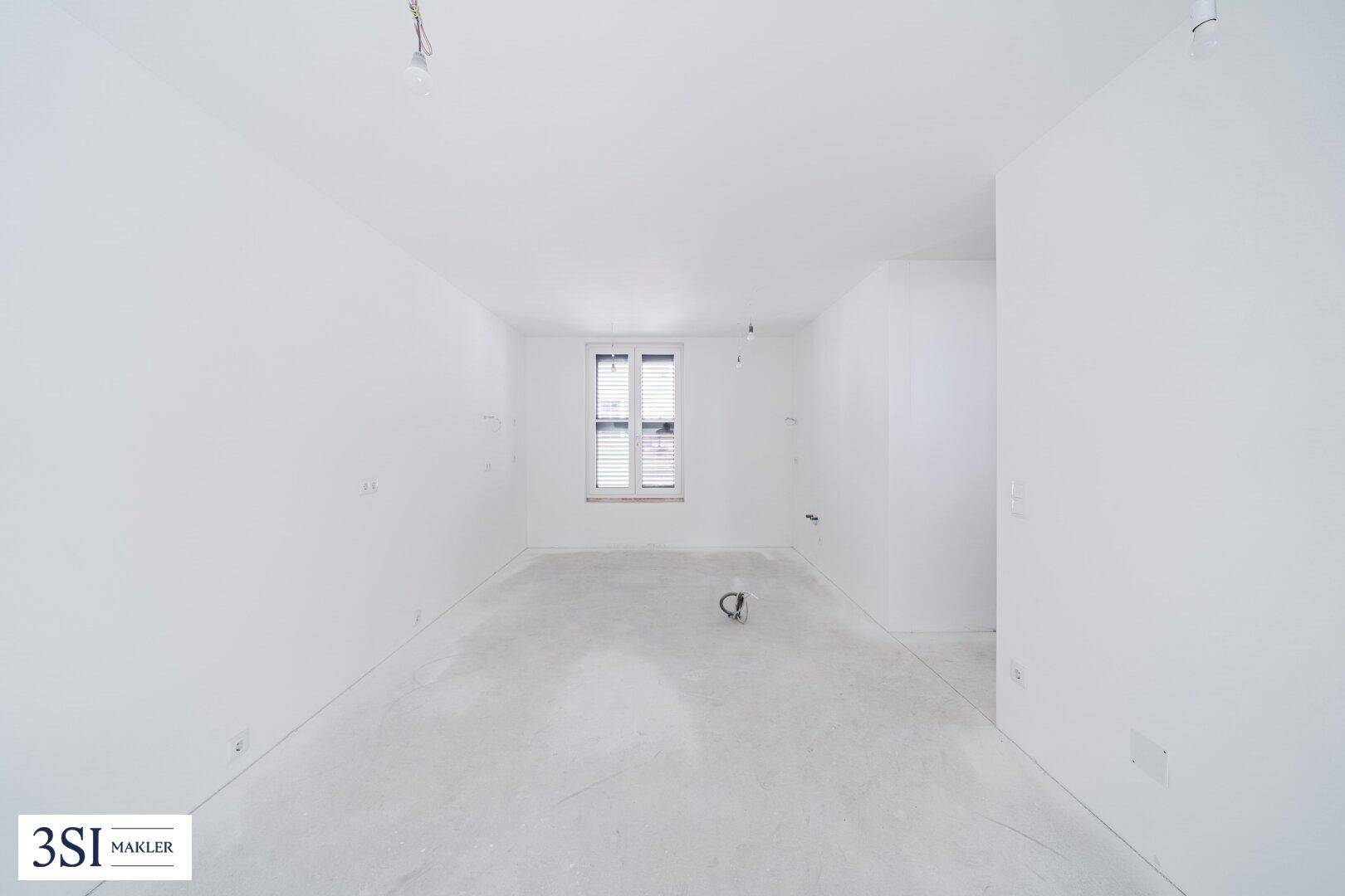 Unfertiger Raum mit Fenster und Rohbau-Charakter, ideal für Lager oder Technikraum.