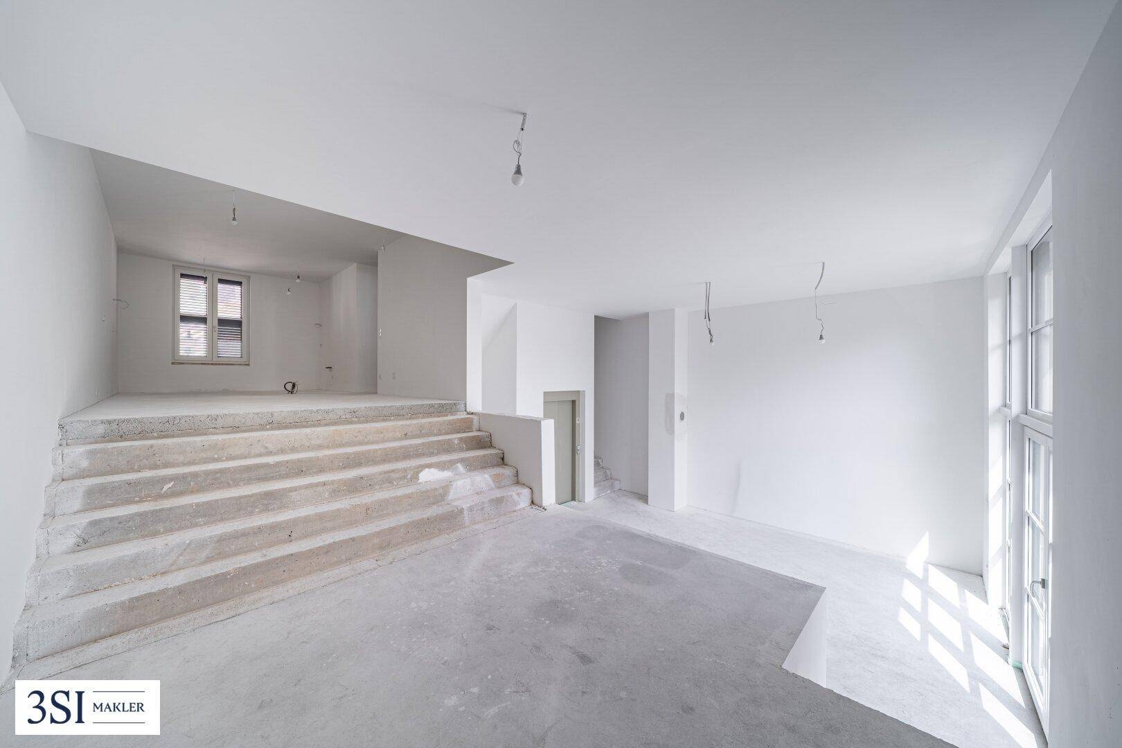 Unfertiger Innenraum mit Betontreppe und Rohbau-Charakter, bereit für den weiteren Ausbau.