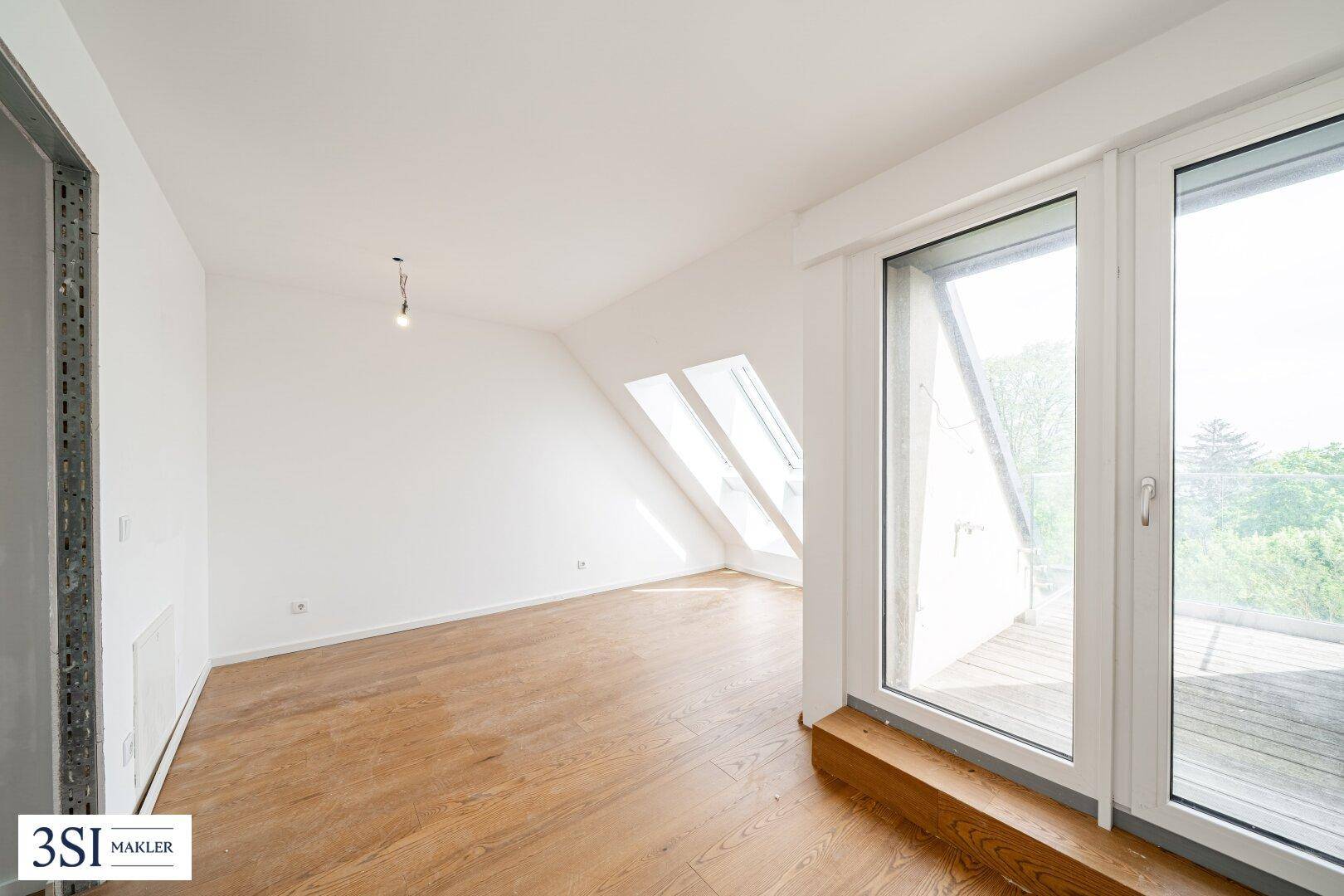 Helles Schlafzimmer im Dachgeschoss mit Dachfenstern, Holzboden und Zugang zu einer Terrasse.