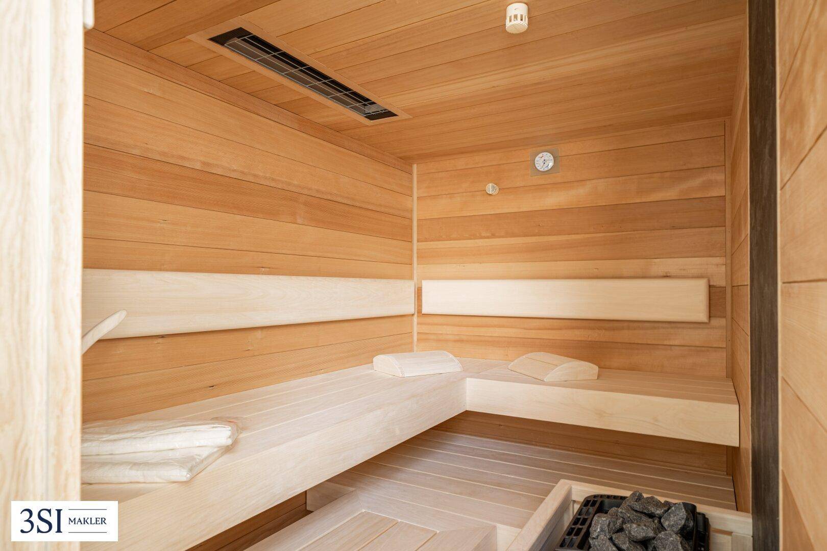 Gemütliche Holzsauna mit Bänken und Heizofen, ideal zur Entspannung.