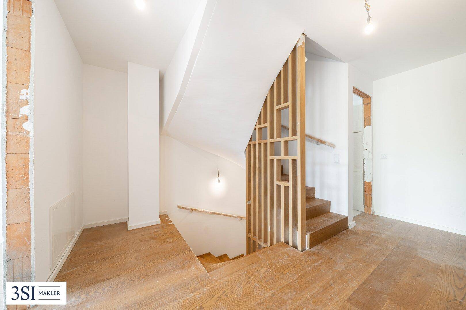 Unfertiger Treppenbereich mit Holzstufen, Geländer und Holzboden im Neubau.