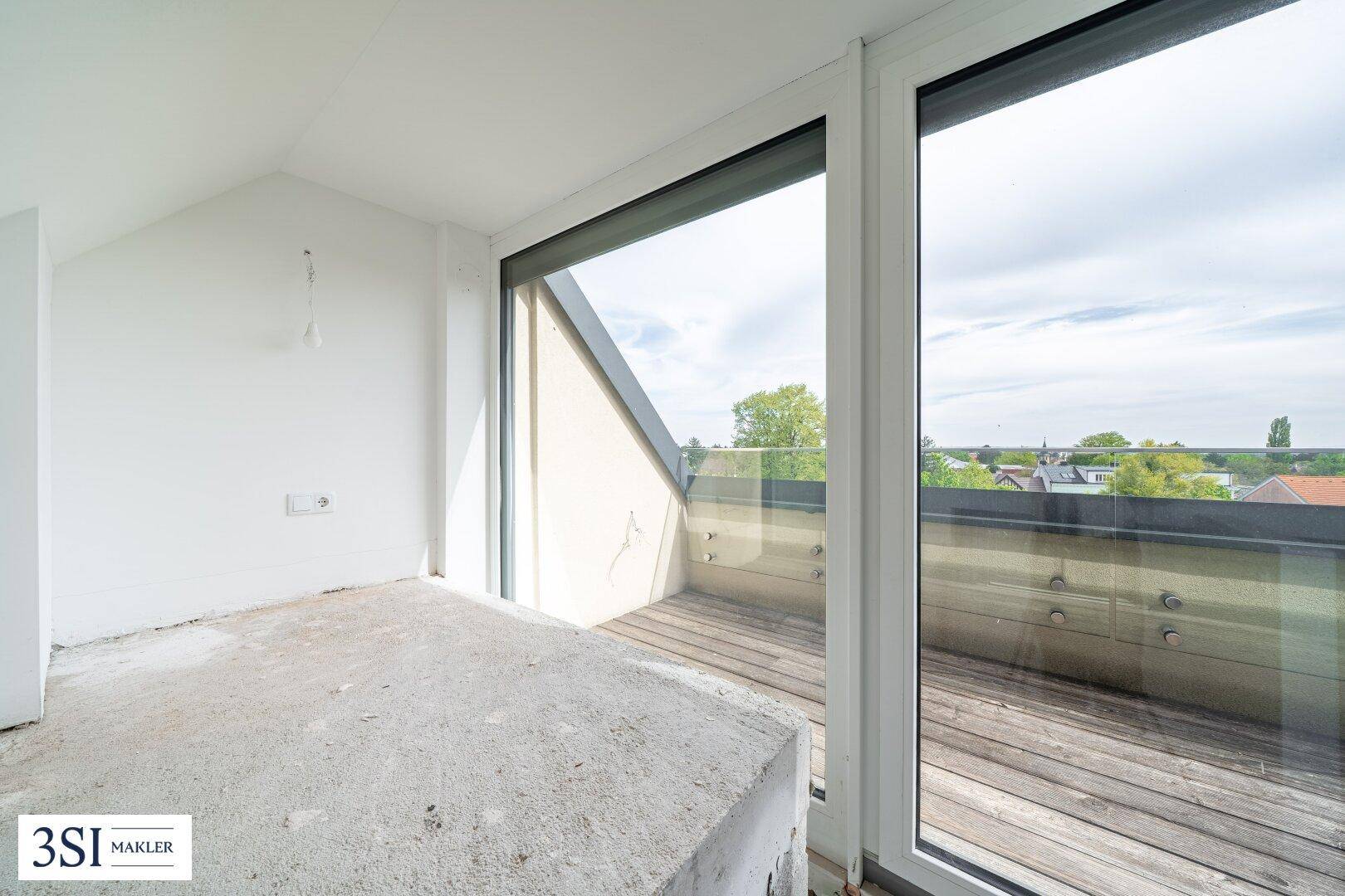 Rohbau mit Zugang zu einem Balkon und Blick auf die Umgebung.