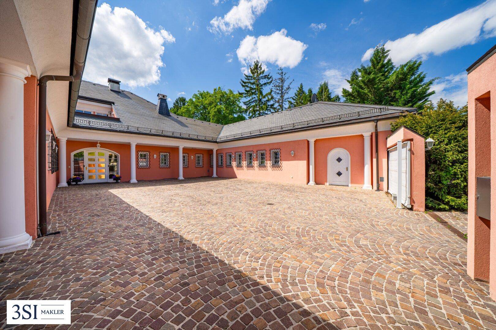 Großer gepflasterter Innenhof mit viel Platz und Zugang zu den Gebäudeteilen.