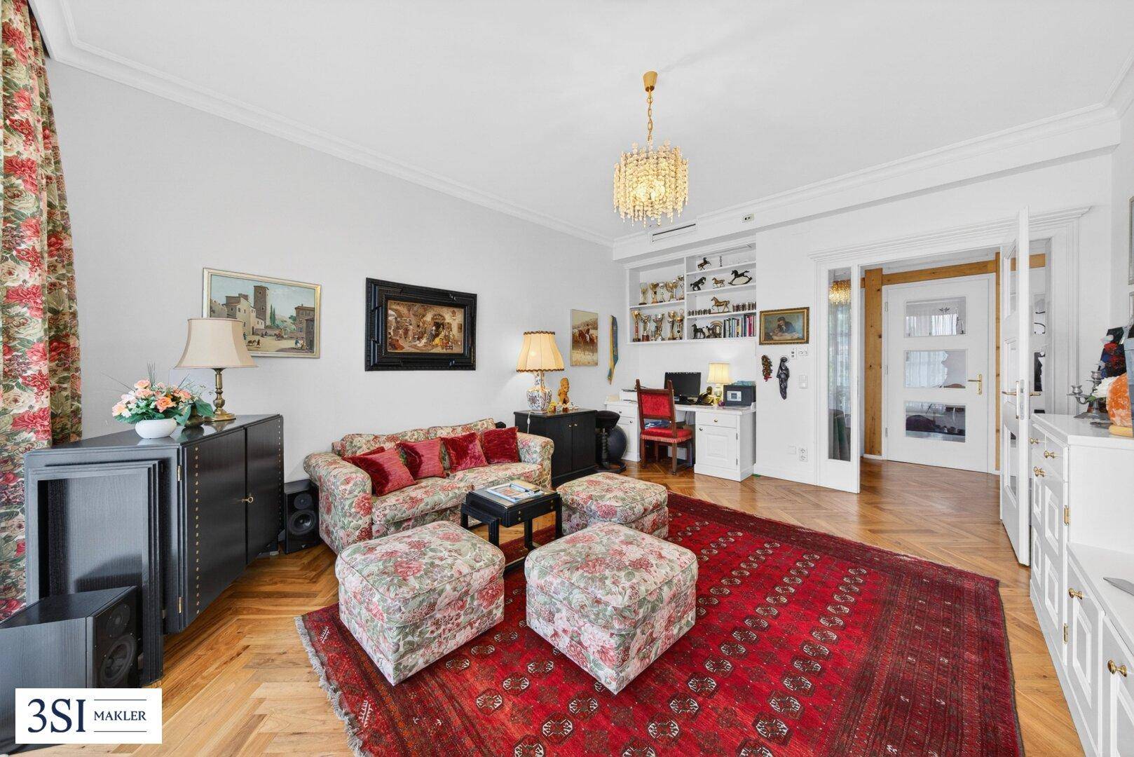 Gemütliches Wohnzimmer mit Parkettboden, eleganten Möbeln und einem Kronleuchter.
