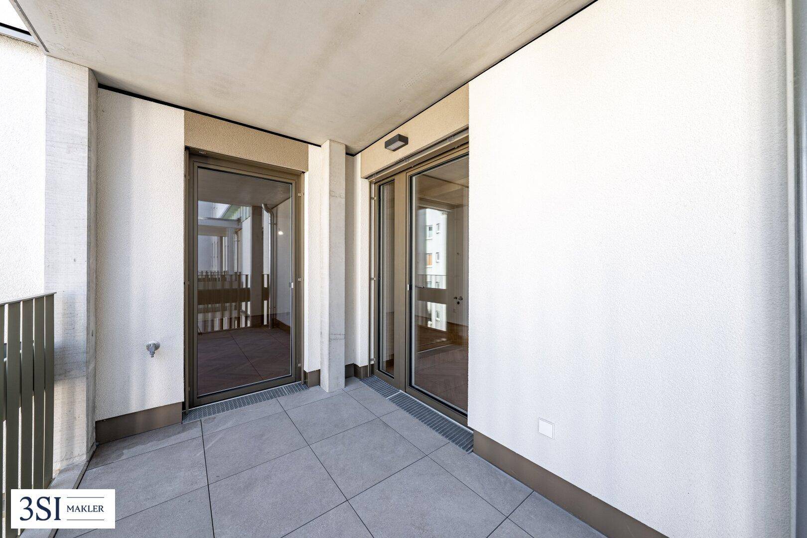 Heller Balkon mit Fliesenboden und Zugang zu Innenräumen, bietet Platz im Freien.