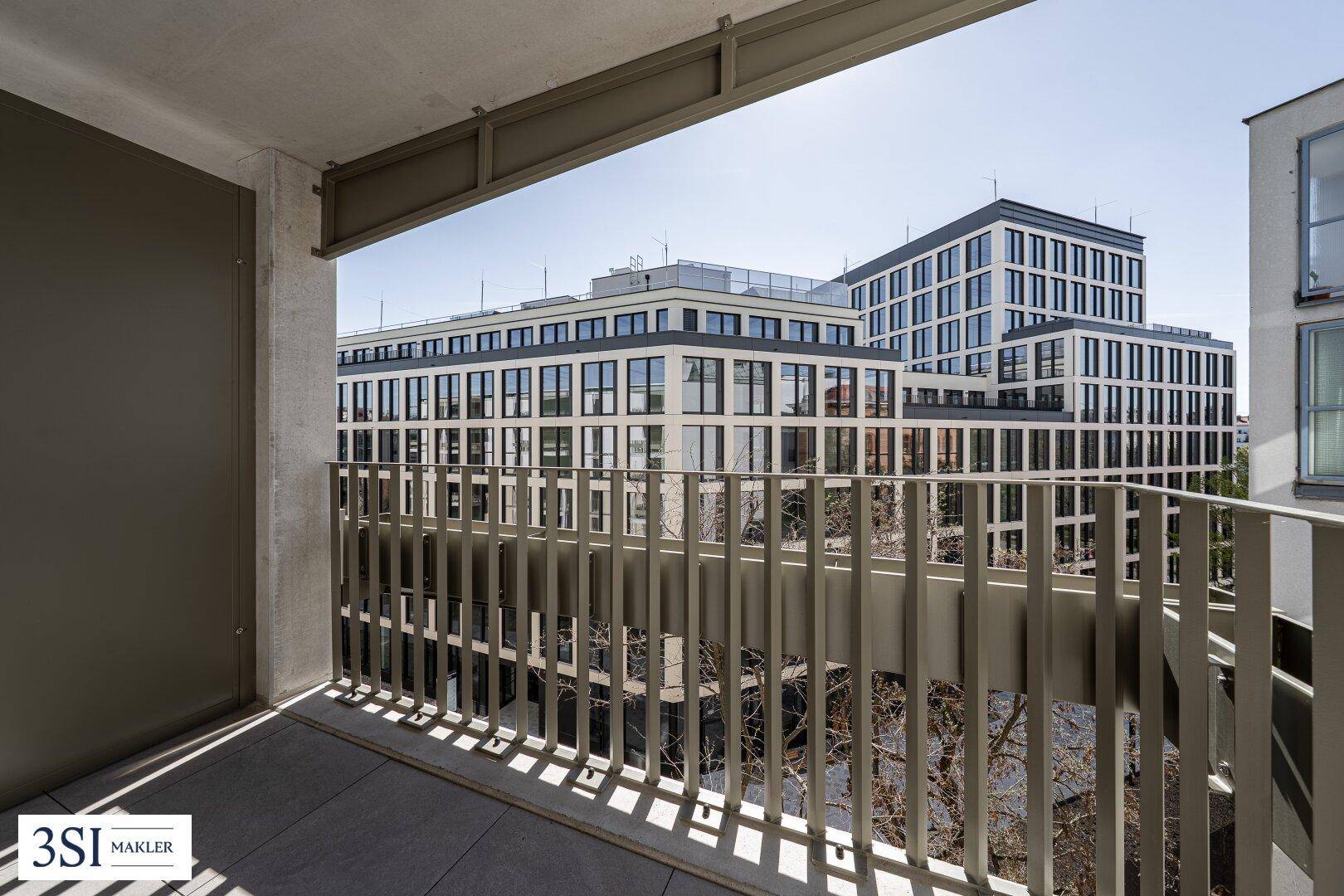 Heller Balkon mit Blick auf moderne Gebäude und die städtische Umgebung.