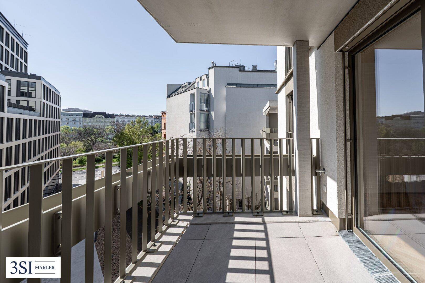 Geräumiger Balkon mit Fliesenboden und Blick auf die umliegende Stadtbebauung.
