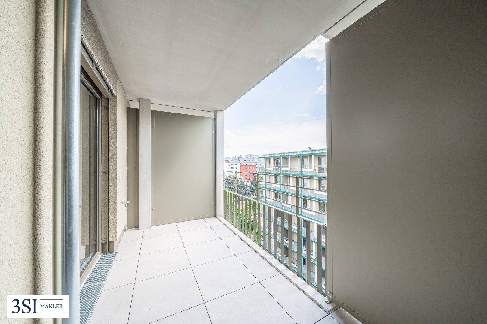 Geräumiger Balkon mit Fliesenboden und Blick auf die umliegende Bebauung.