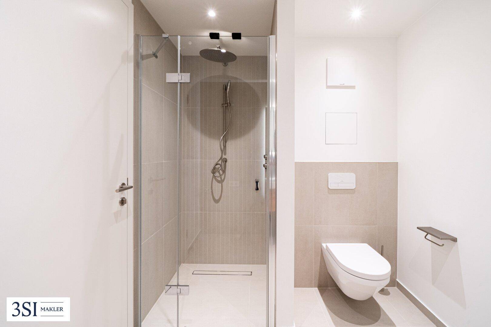 Zeitgemäßes Badezimmer mit großer begehbarer Dusche und Wand-WC.