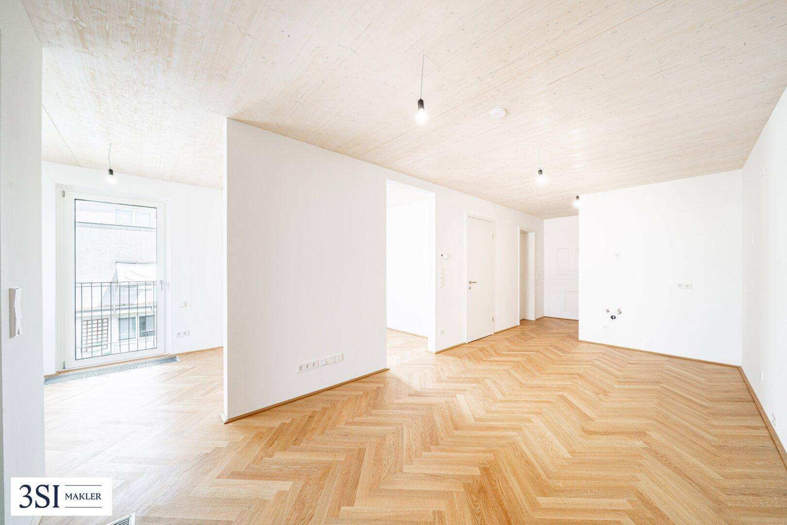 Geräumiger, heller Wohnbereich mit elegantem Fischgrätparkett und modernem Holzdecken-Design.