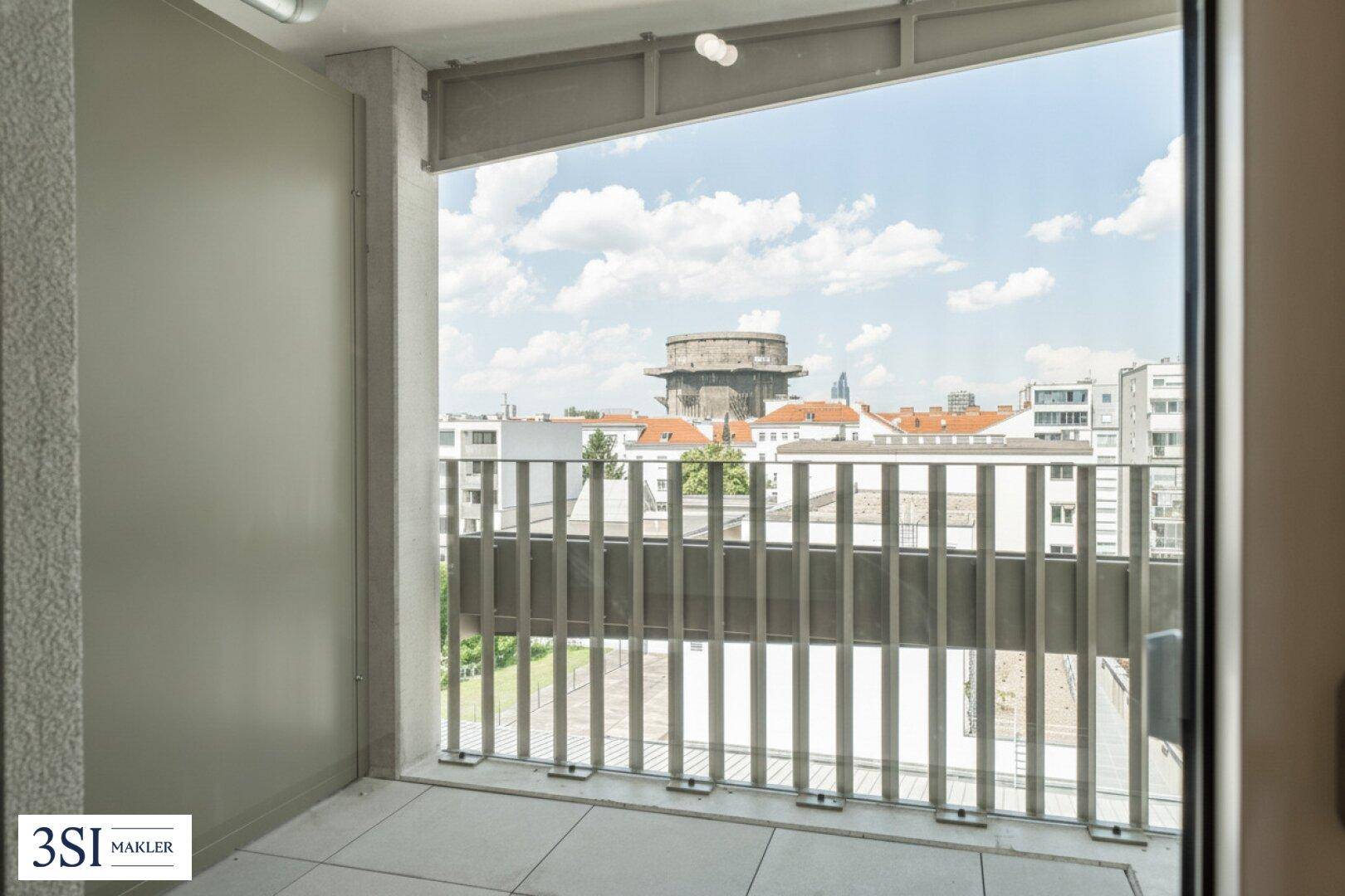 Balkon mit Fliesenboden und modernem Geländer bietet einen weiten Blick auf die Stadt.