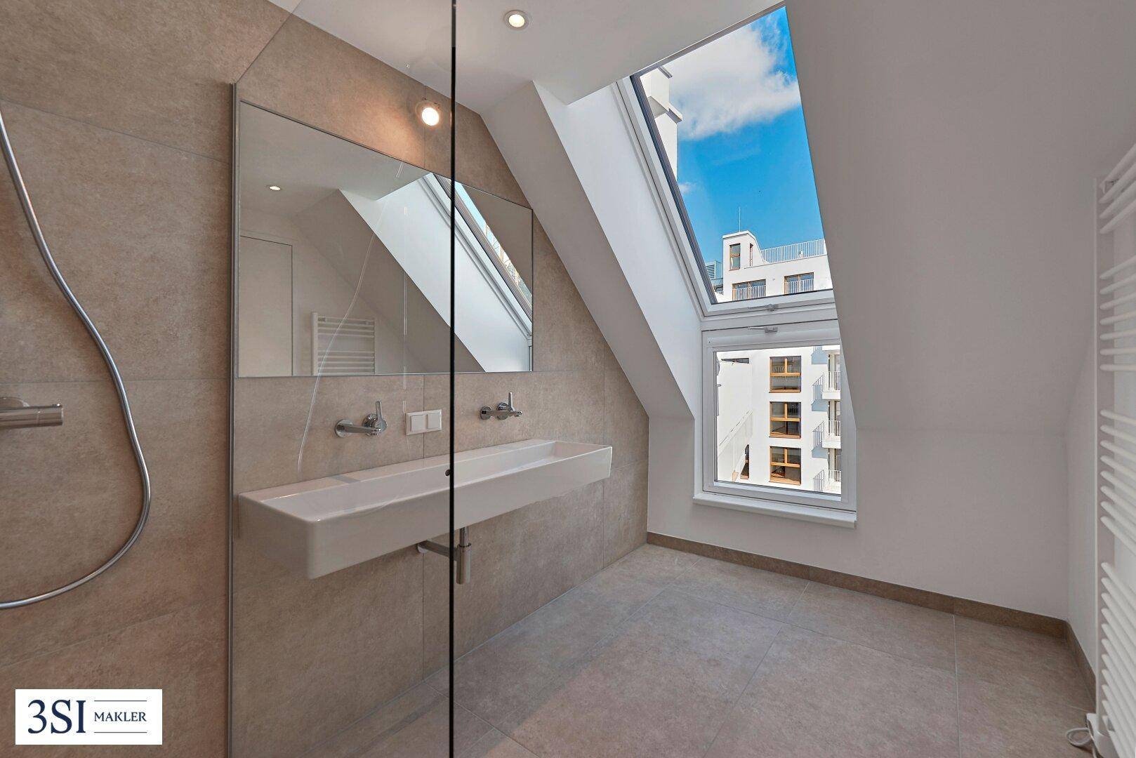 Helles Badezimmer mit begehbarer Dusche, Dachfenster und beigefarbenen Fliesen.