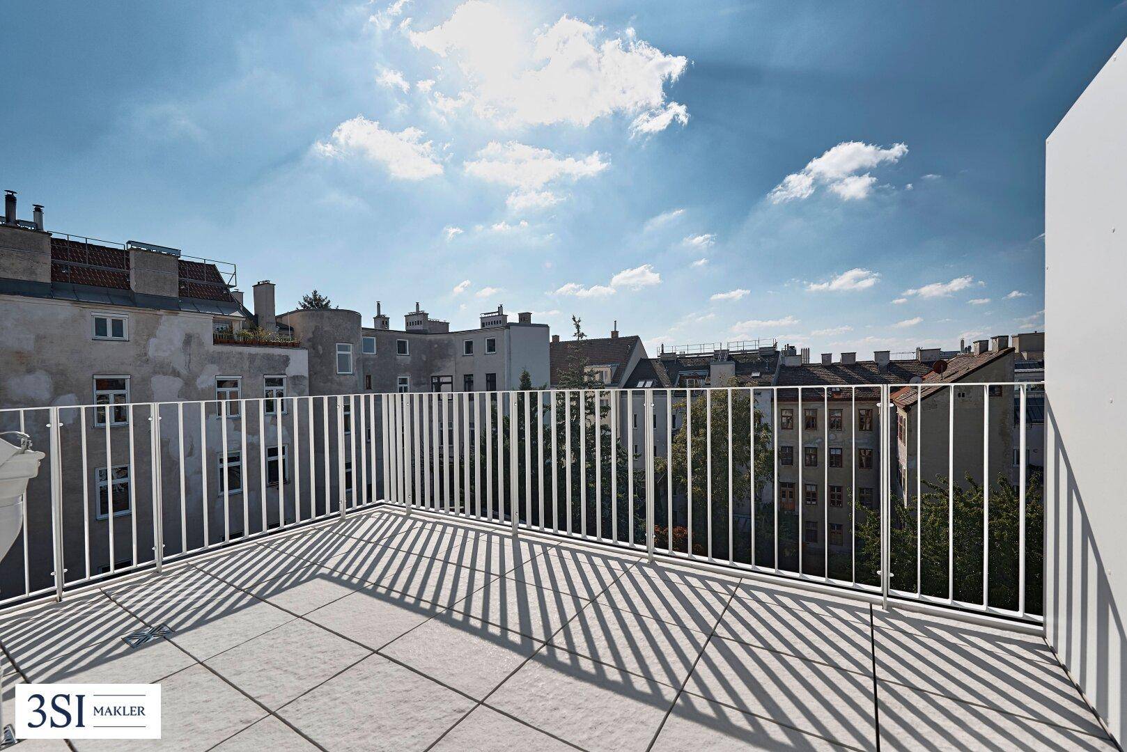 Sonniger Terrassenbereich mit weitem Blick über die Dächer der Stadt.