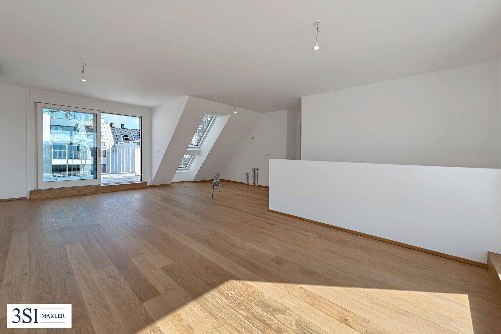 Geräumiger, unmöblierter Wohn-Essbereich mit Holzboden, Dachschrägen und viel Tageslicht.