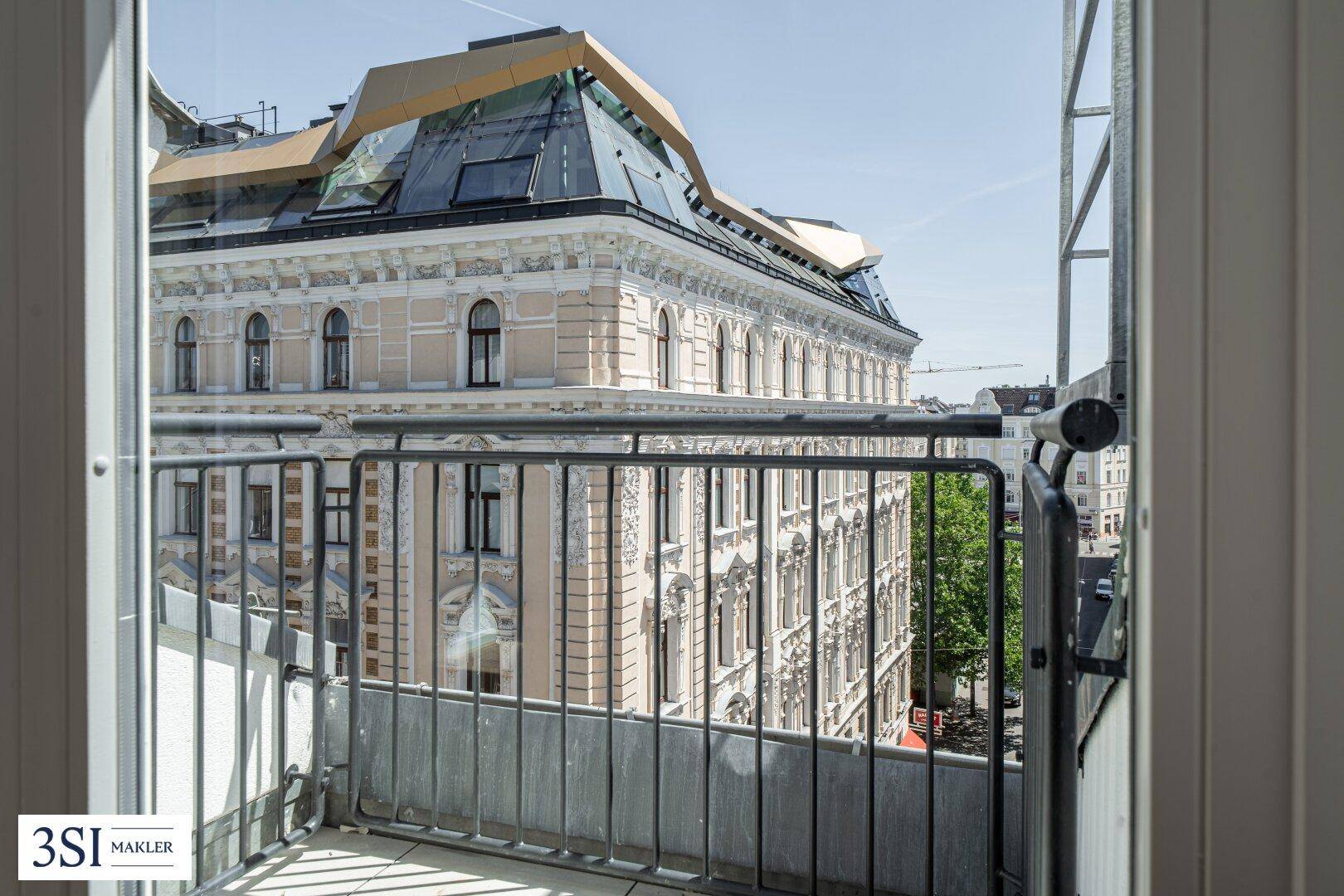 Blick von einem französischen Balkon auf die historische Stadtarchitektur und die Straße.