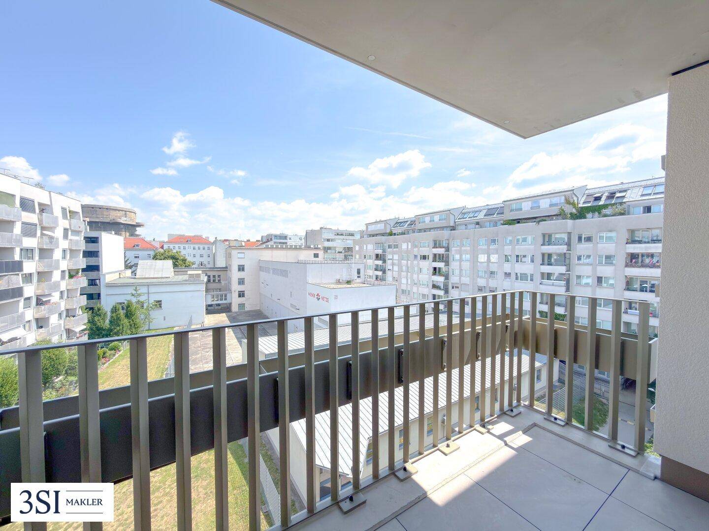 Geräumiger Balkon mit Fliesenboden und weitem Blick über die städtische Umgebung.