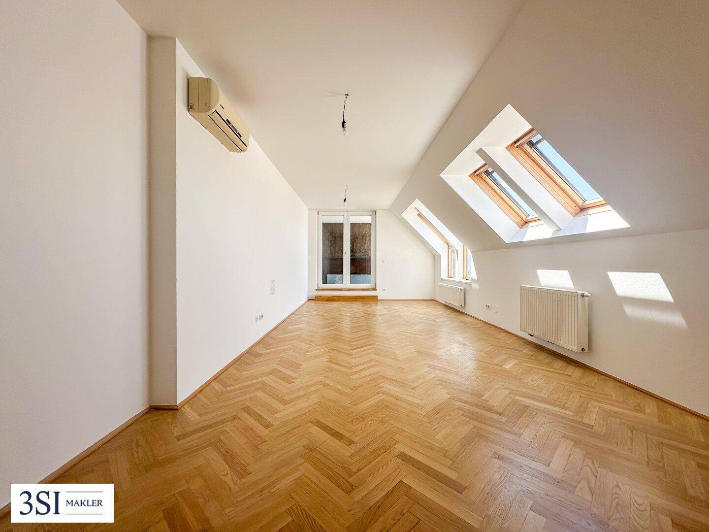 Geräumiges Wohn-Esszimmer mit Fischgrätparkett, Dachschrägen und hellen Dachfenstern.