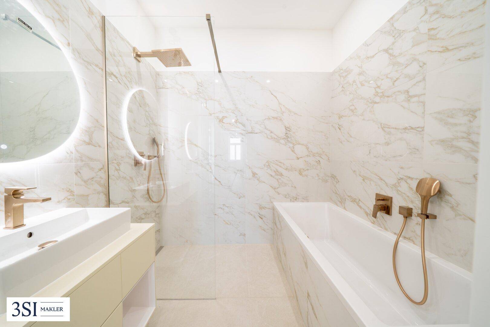 Luxuriöses Badezimmer mit Marmorfliesen, begehbarer Dusche, Badewanne und eleganten Armaturen.