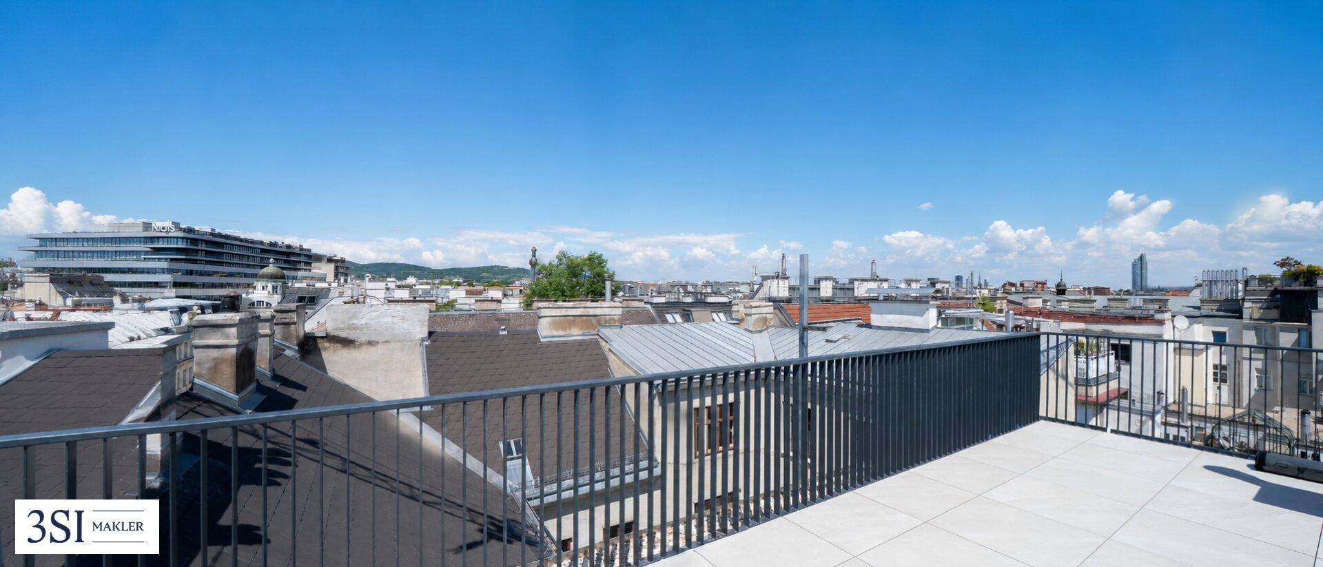 Weitläufige Dachterrasse mit Panoramablick über die Stadt und die umliegende Landschaft.