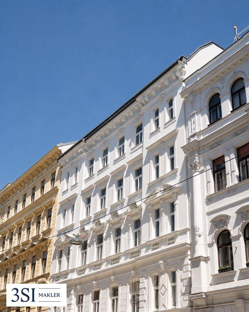 Historische Fassaden von eleganten Altbaugebäuden unter strahlend blauem Himmel.