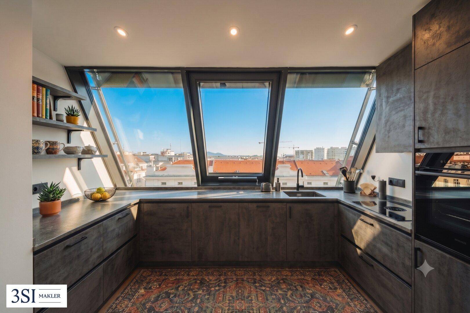Moderne Küche mit schrägen, großen Fenstern, die einen weiten Blick über die Stadt bieten.