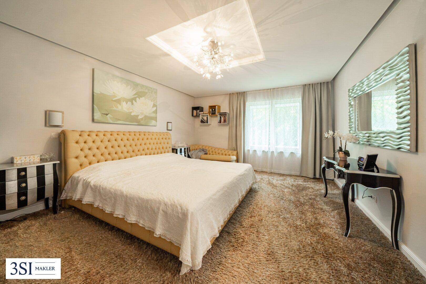 Gemütliches Schlafzimmer mit großem Bett, Teppichboden und eleganten Möbeln.