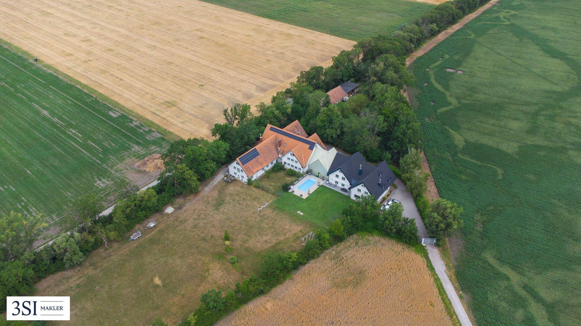 Luftaufnahme des Anwesens mit Pool, umgeben von Feldern und Bäumen in ländlicher Umgebung.