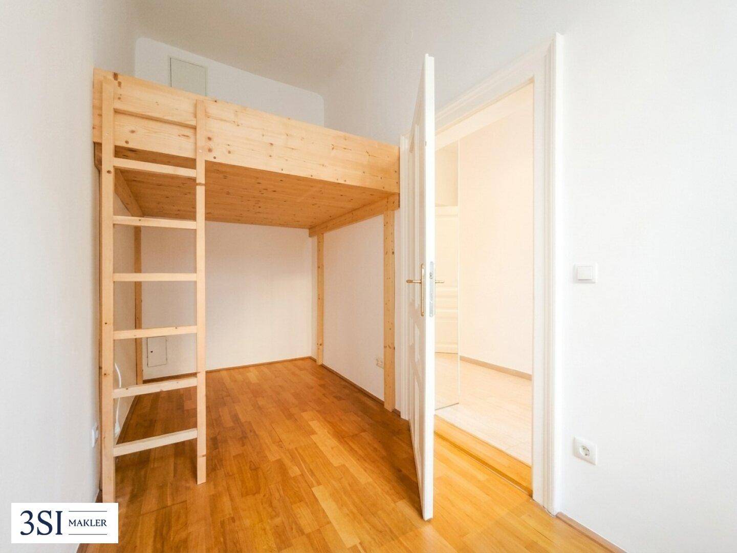 Schlafzimmer mit Holzboden und einem hohen Holz-Hochbett, das den Raum optimal nutzt.