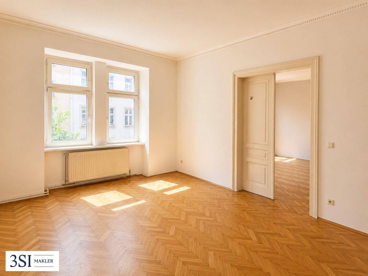 Unmöbliertes Schlafzimmer mit Fischgrätparkett, hohen Decken und viel Tageslicht.