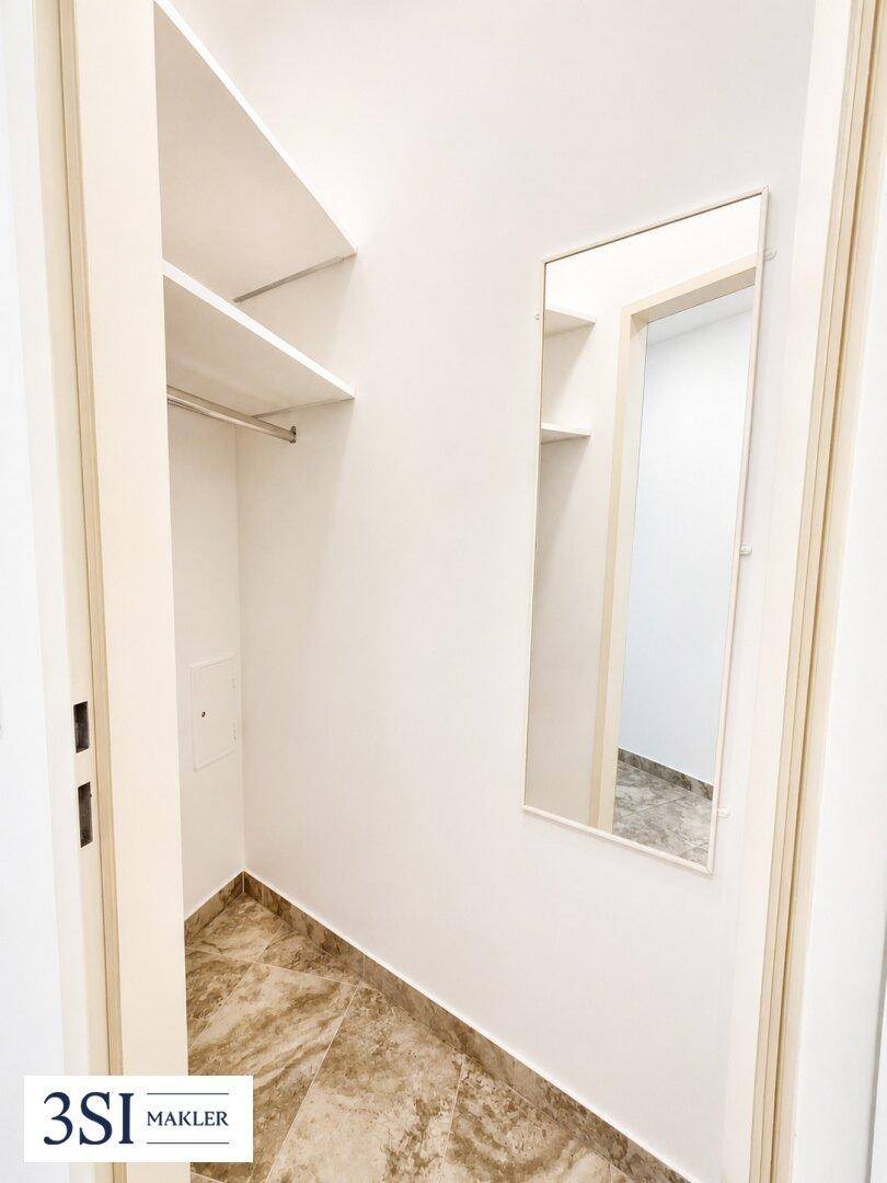 Praktischer Abstellraum mit Regalen und Spiegel, ideal als begehbarer Kleiderschrank.