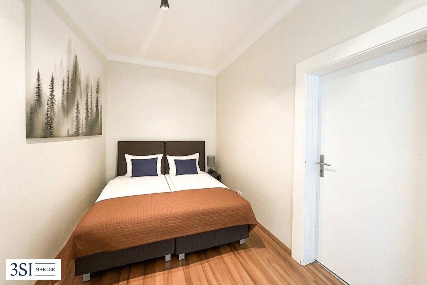 Gemütliches Schlafzimmer mit Doppelbett, Holzboden und einem modernen Wandbild.