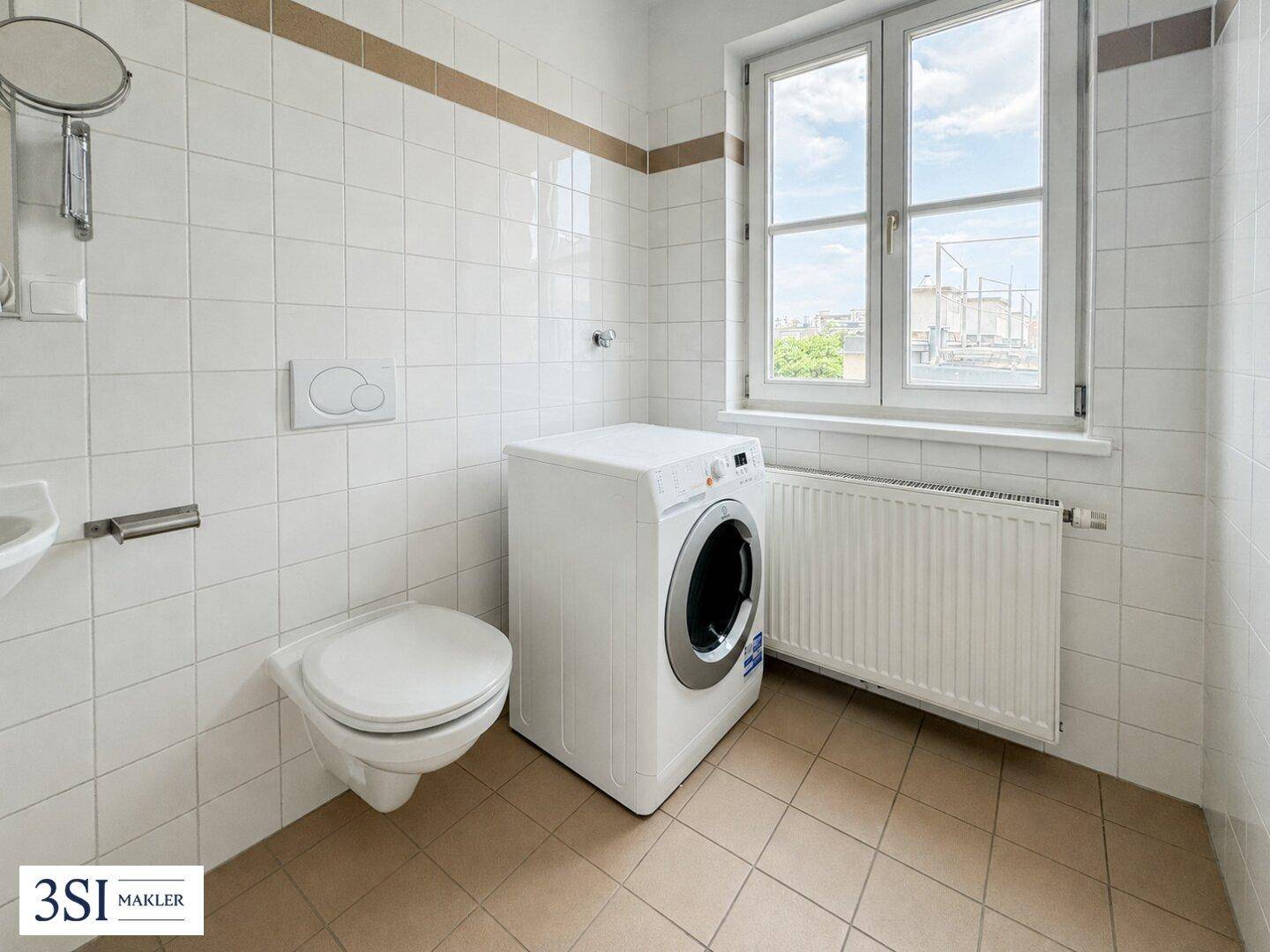 Gefliestes WC mit Fenster, Waschmaschine und Wand-WC in funktionalem Design.