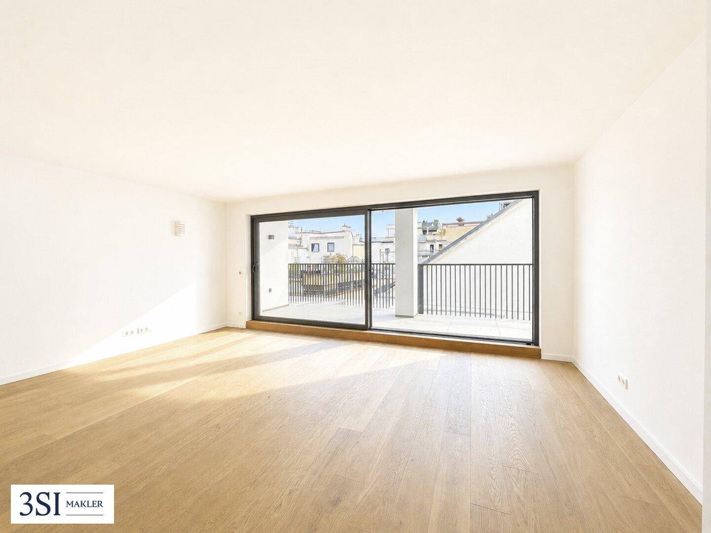 Geräumiges, lichtdurchflutetes Wohnzimmer mit hellem Holzboden und Zugang zu einem Außenbereich.