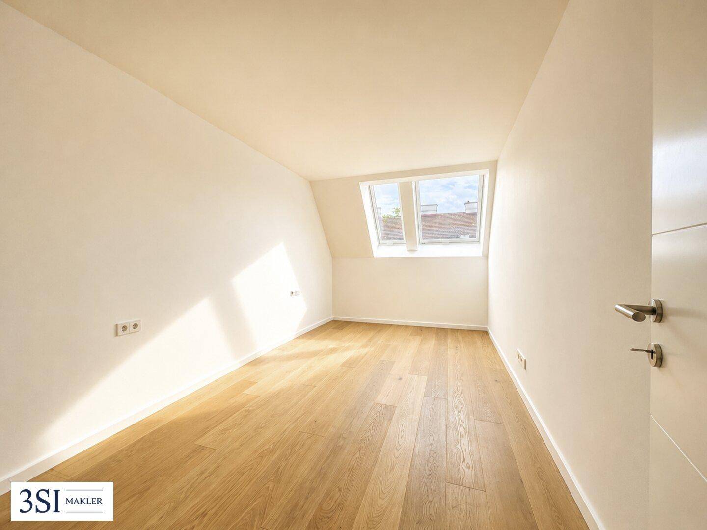 Lichtdurchflutetes Dachzimmer mit Holzboden und schrägen Wänden, ausgestattet mit zwei Dachfenstern.