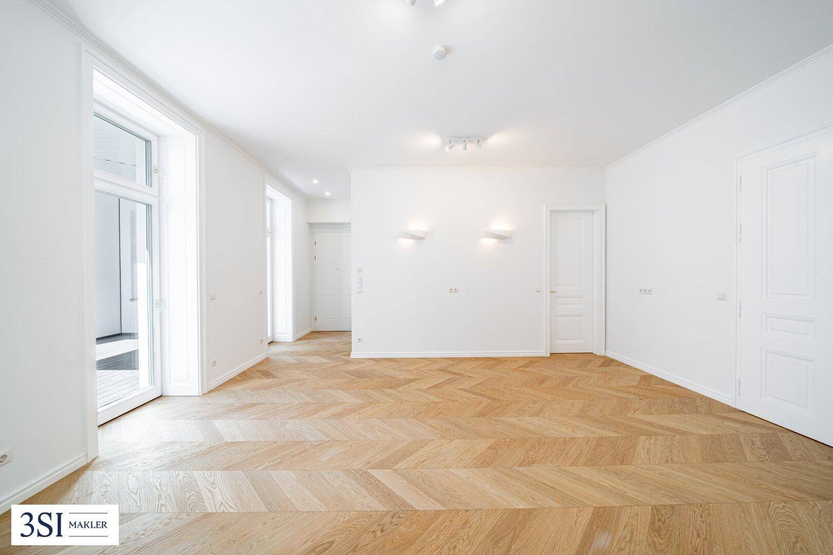 Heller Raum mit elegantem Fischgrätparkett und hohen Fenstern, ideal für Wohn- oder Schlafbereich.