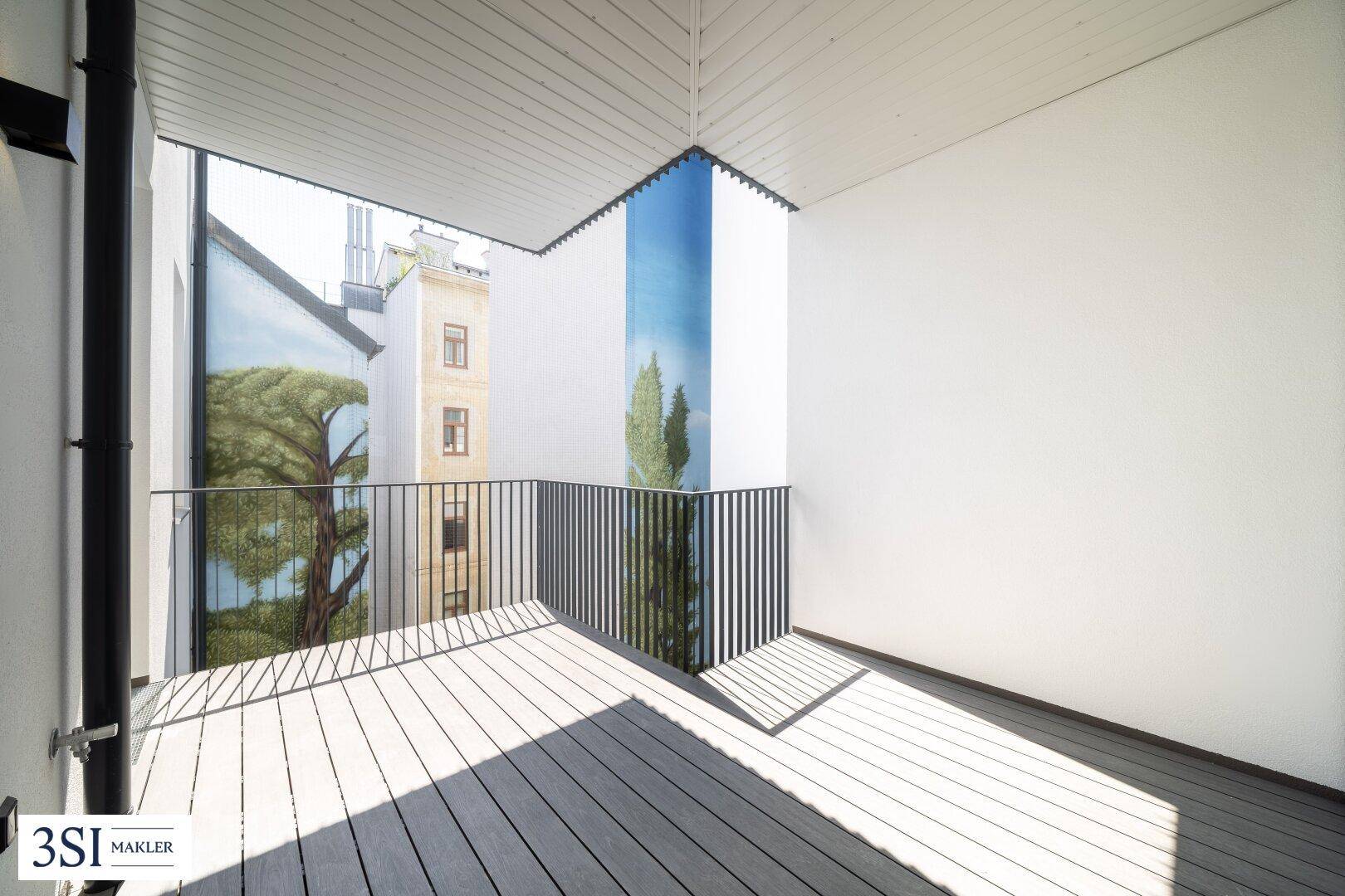 Heller Balkon mit Holzboden und künstlerischer Wandgestaltung, bietet viel Privatsphäre.