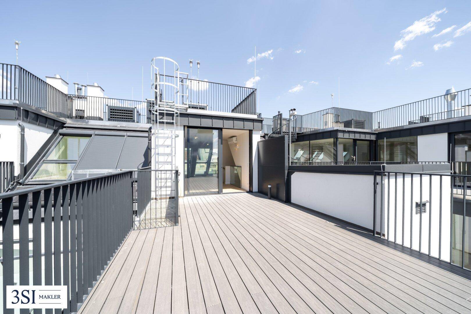 Geräumige Dachterrasse mit Holzboden und Blick auf die Umgebung.