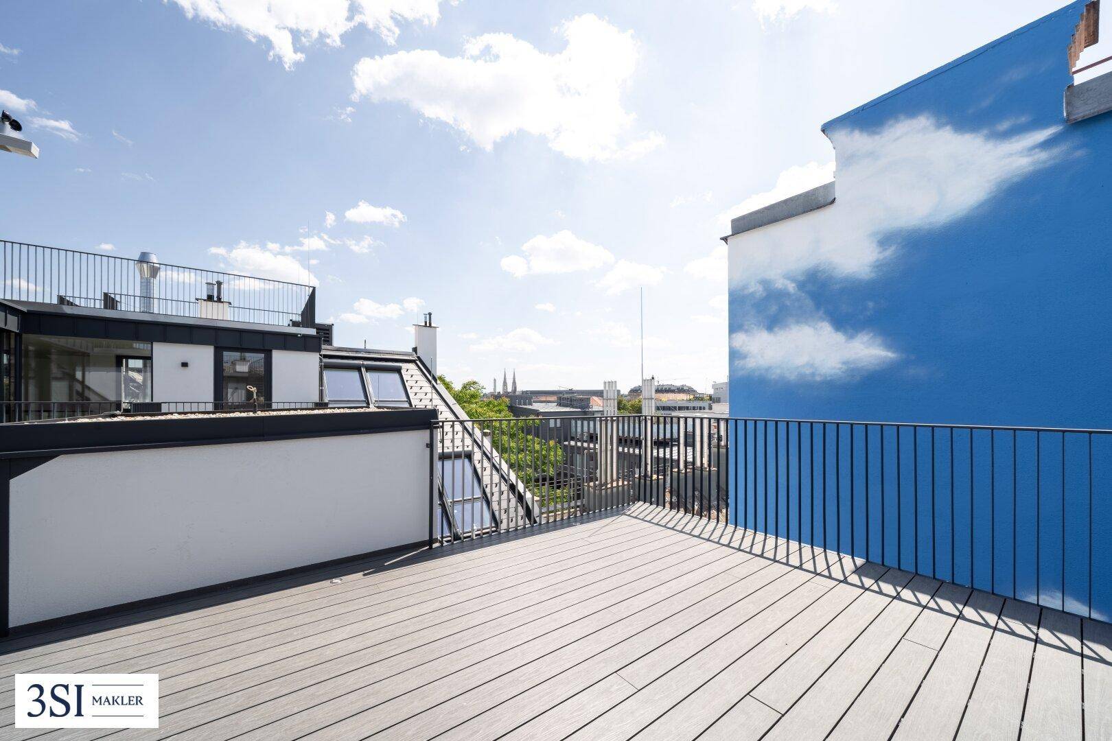 Weitläufige Dachterrasse mit Holzboden und Panoramablick über die Stadt.
