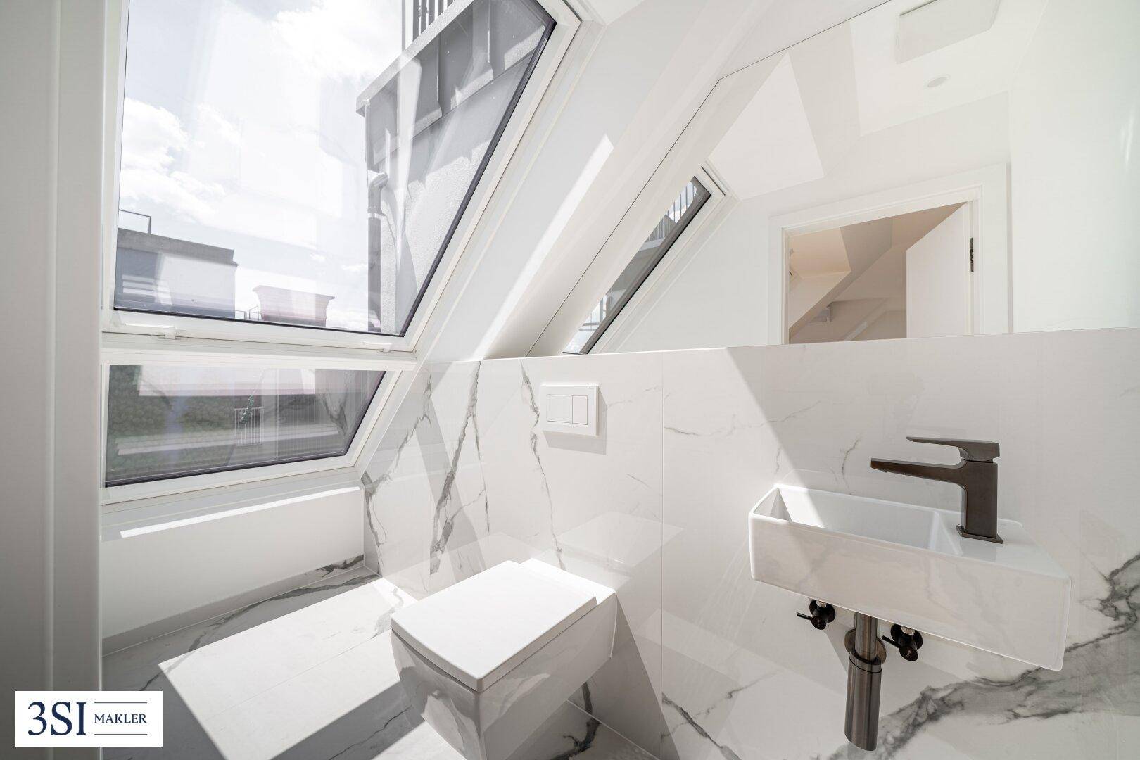 Modernes Gäste-WC mit Marmoroptikfliesen, wandhängendem WC und Dachfenstern.